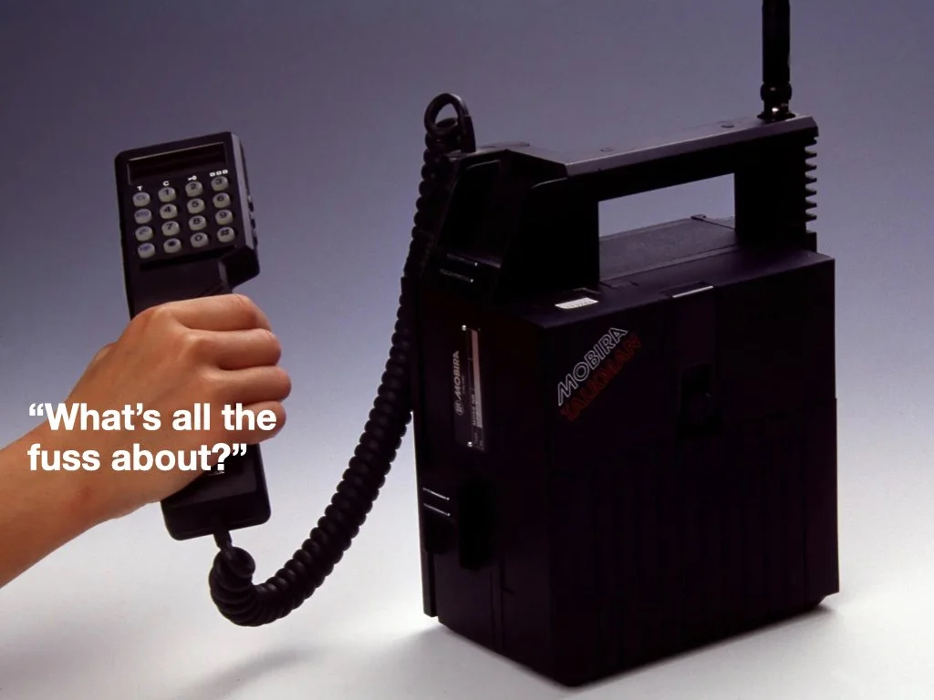 Early mobile phones compared to the evolution of AI.